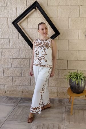 Descubre la elegancia del lino con nuestro conjunto blanco perlado. Camisa de tirantes y pantalón con exclusivos bordados marrones para un estilo auténtico.