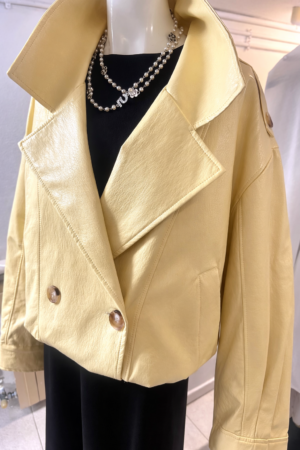 Eleva tu estilo con nuestra cazadora oversize de ecopiel. Diseño sofisticado con solapas, hombros caídos y doble botonadura en tonos vainilla y negro.