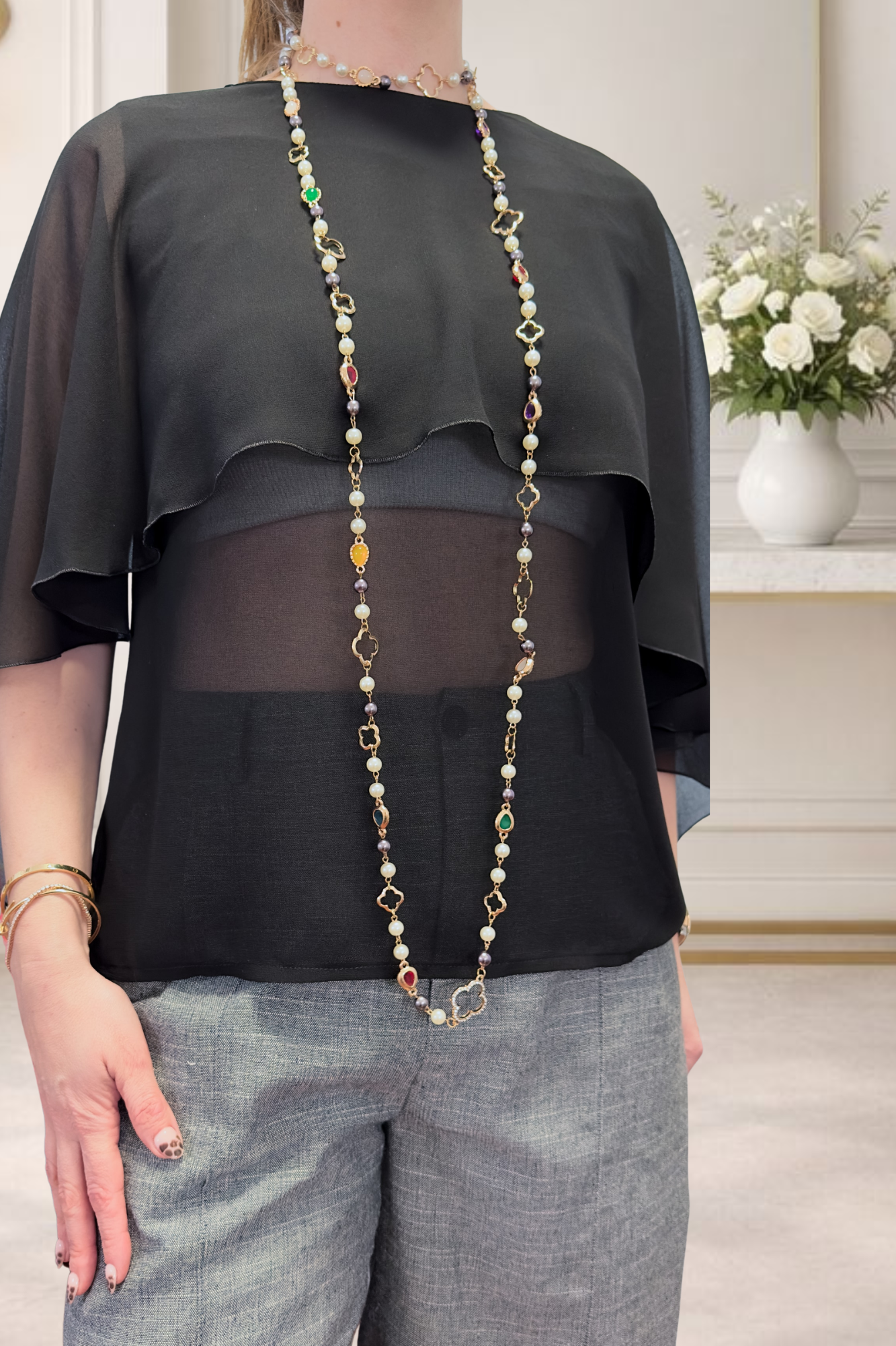 Camisa de gasa con volantes Camisa de gasa negra para mujer de OH.LA con diseño de volantes superpuestos, mangas murciélago y escote en la espalda. Prenda femenina elegante y versátil para un fondo de armario atemporal.