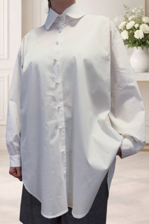 Eleva tu fondo de armario con nuestra camisa blanca oversize. Tejido de algodón elástico y botones de perla para un estilo auténtico y sofisticado.