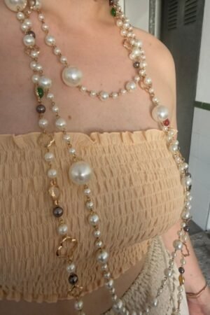Mujer luciendo el top Lola de estilo palabra de honor con textura de bandas engomadas elásticas.