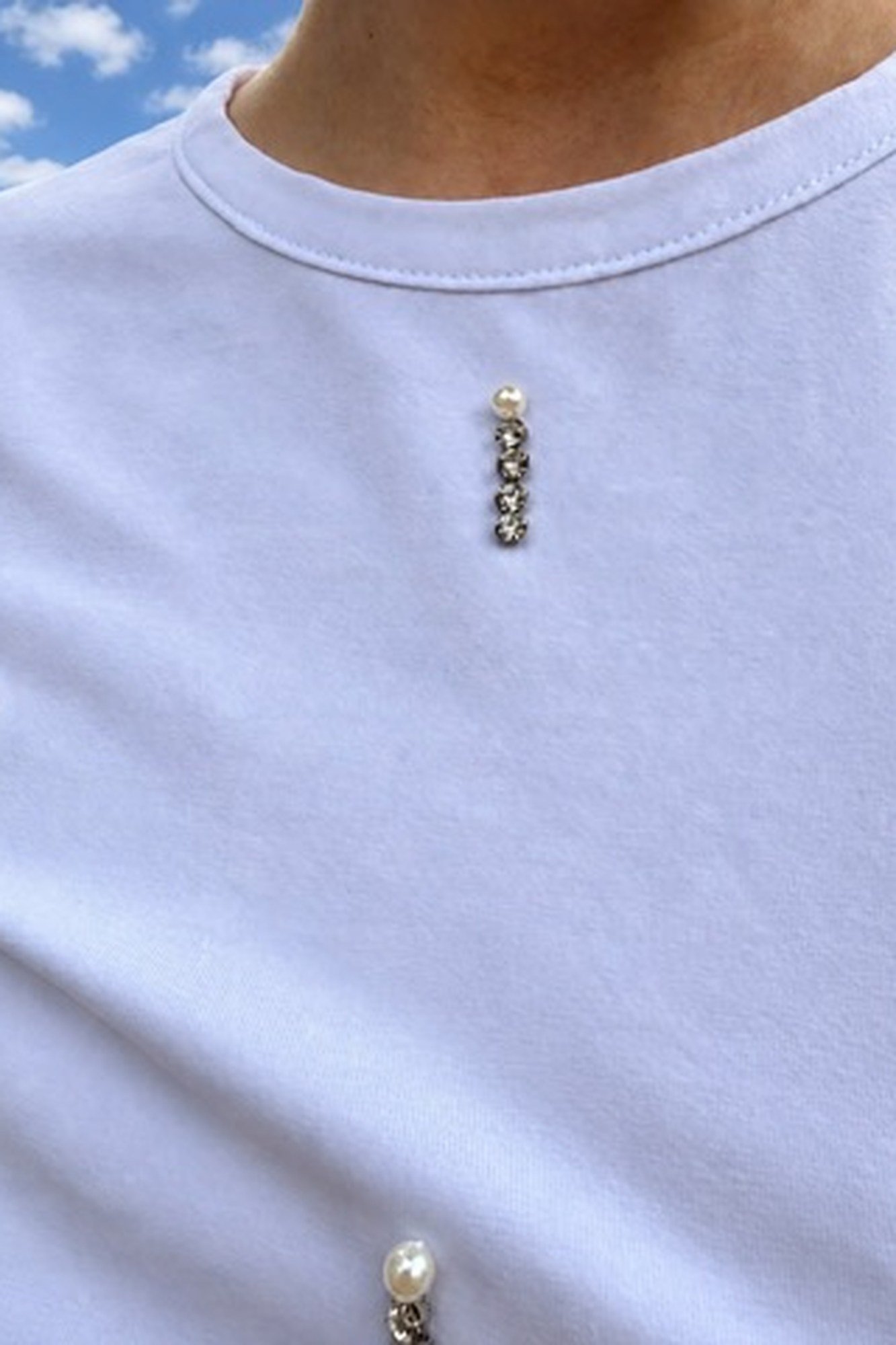 Camiseta de piedras y perlas OH.LA Detalle de los apliques de perlas y piedras de la camiseta blanca de OH.LA